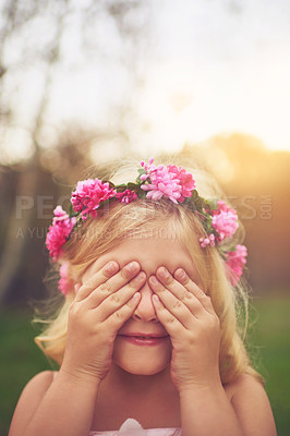 Buy stock photo Shot of a cheerful little girl with her hands on her eyes playing hide and seek outside in nature