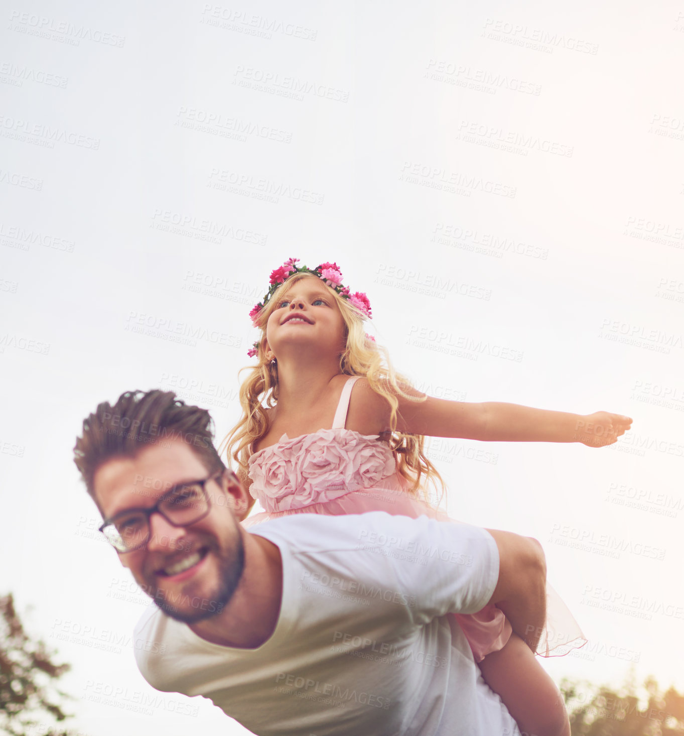 Buy stock photo Shot of a happy father giving his daughter a piggyback ride outside in nature