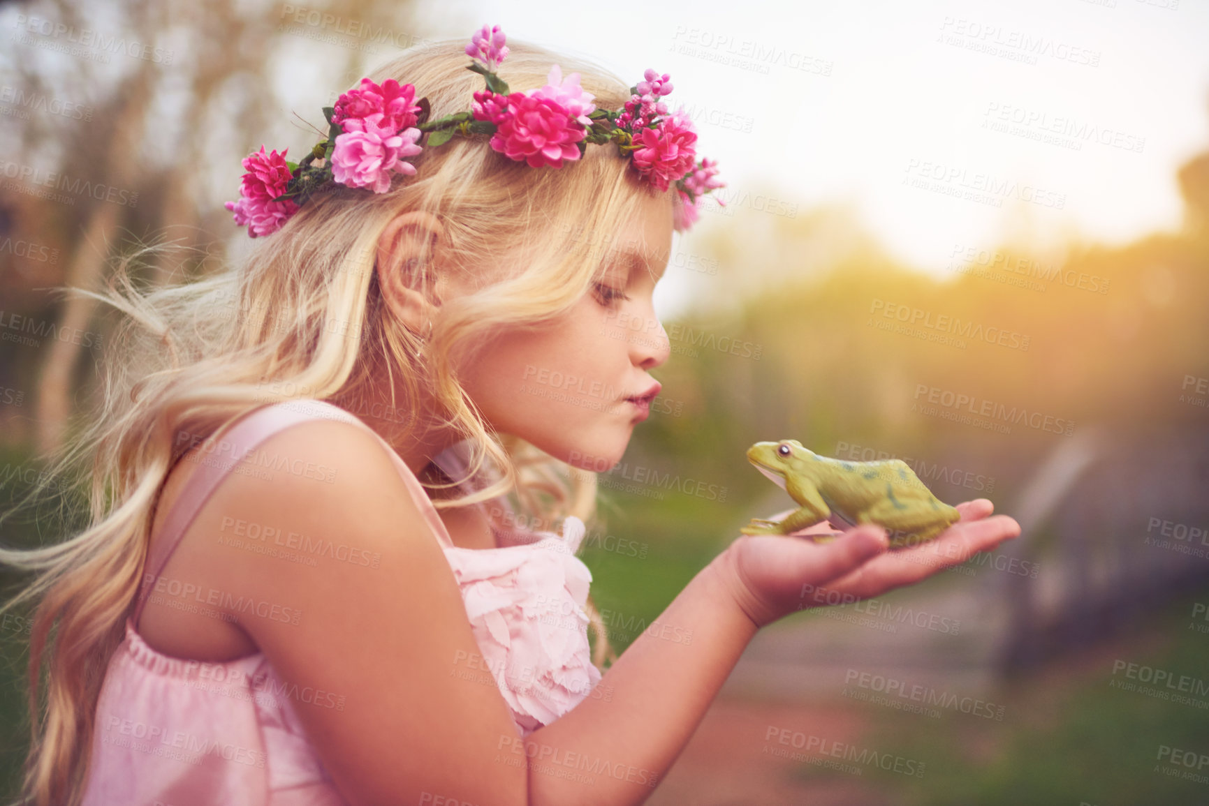 Buy stock photo Little girl, princess and frog with kiss for fairy tale, love or care in nature with flower crown. Young, child or kid with animal or creature for fantasy, imagination or nurture with outdoor sunrise