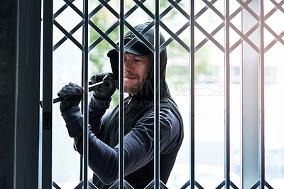 Buy stock photo Shot of a male burglar using a steel weapon to break into a house