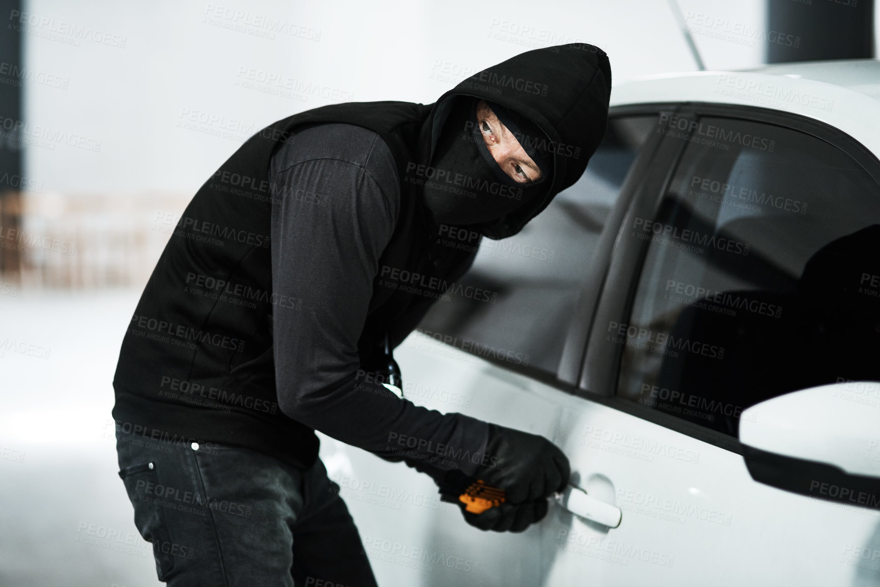 Buy stock photo Man, vehicle and steal with criminal tool, picking lock and illicit behaviour or automobile jacking. Theft, makeshift key and hooded offender or disabling car alarm, parking lot and illegal burglary