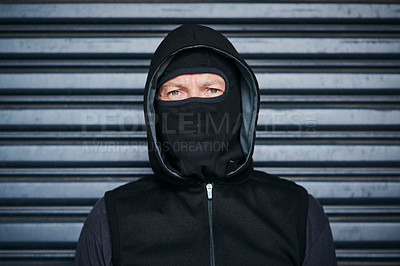 Buy stock photo Portrait of a male burglar posing against a dark background