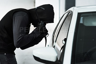 Buy stock photo Shot of a masked criminal using a steel weapon to break inside a car
