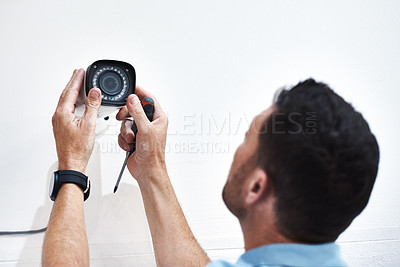 Buy stock photo Shot of a mature man installing a security camera on a building