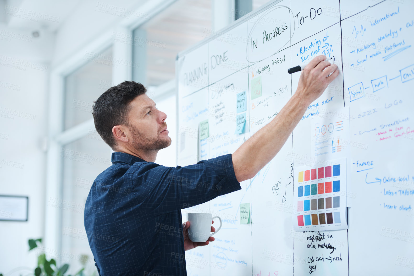 Buy stock photo Shot of a handsome mature male designer working on a whiteboard in the office