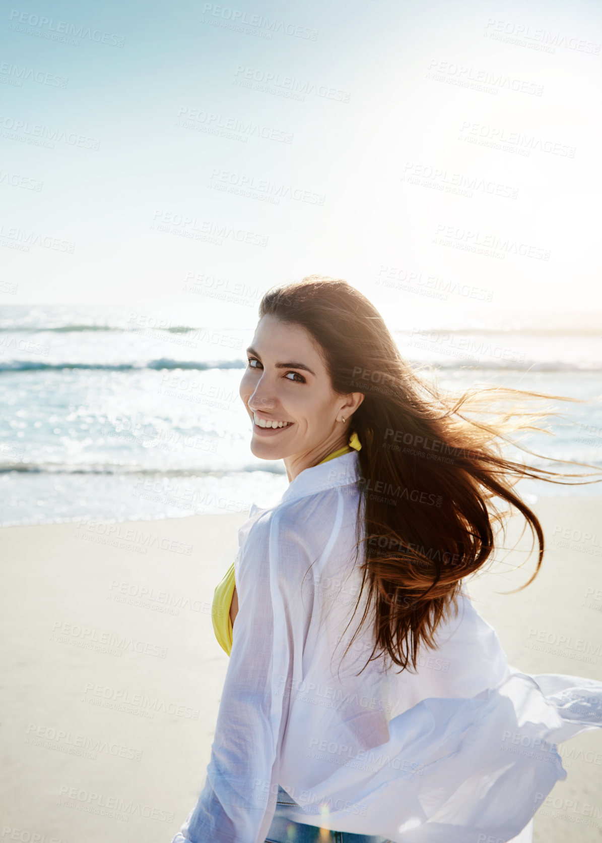 Buy stock photo Shot of a beautiful young woman enjoying her day at the beach