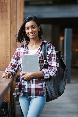 Buy stock photo Cropped portrait of an attractive young female student holding textbooks while standing outside on campus