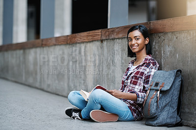 Buy stock photo Full length portrait of an attractive young female student reading a book while sitting outside on campus