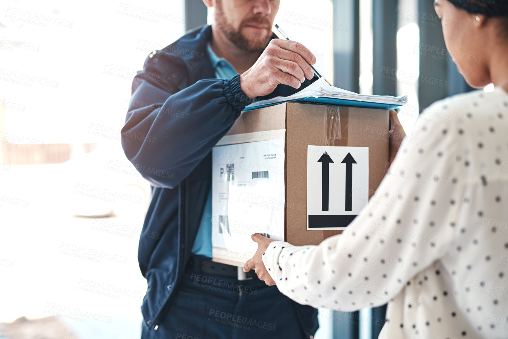 Buy stock photo Shot of an unrecognizable delivery man handing a package to a female customer