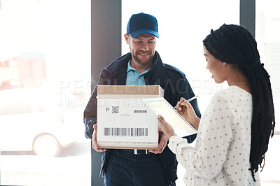 Buy stock photo Shot of a handsome delivery man getting a signature from a female customer for her order