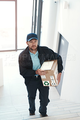 Buy stock photo Full length shot of a handsome delivery man heading up a flight of stairs with a customer's order
