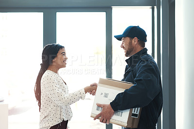 Buy stock photo Shot of a handsome delivery man shaking hands with a female customer