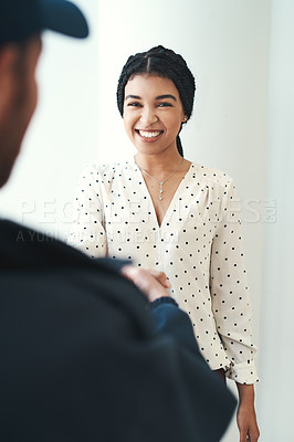 Buy stock photo Shot of an unrecognizable male courier shaking hands with a female customer
