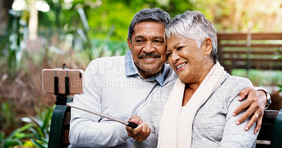 Buy stock photo Park, bench and selfie with senior couple, smile and bonding on outdoor adventure together. Old man, woman and digital photography in nature with love, hug or memory for retirement, marriage and tech