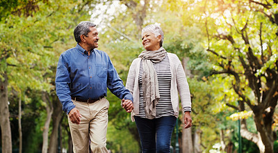 Buy stock photo Holding hands, walking and senior couple in park for bonding, commitment and loving relationship. Retirement, marriage and happy elderly man and woman relax together in nature for wellness and health
