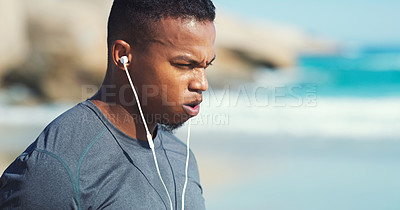 Buy stock photo Fitness, headphones and black man with breathing at beach to relax on audio, streaming and training. Workout, music and runner at ocean on break, listening to podcast and exercise challenge in nature
