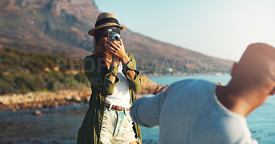 Buy stock photo Cropped shot of a happy young woman photographing her boyfriend at the beach