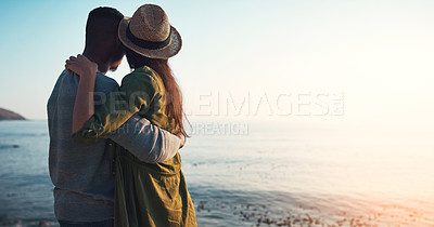 Buy stock photo Rearview shot of an affectionate young couple embracing each other on the beach at sunset