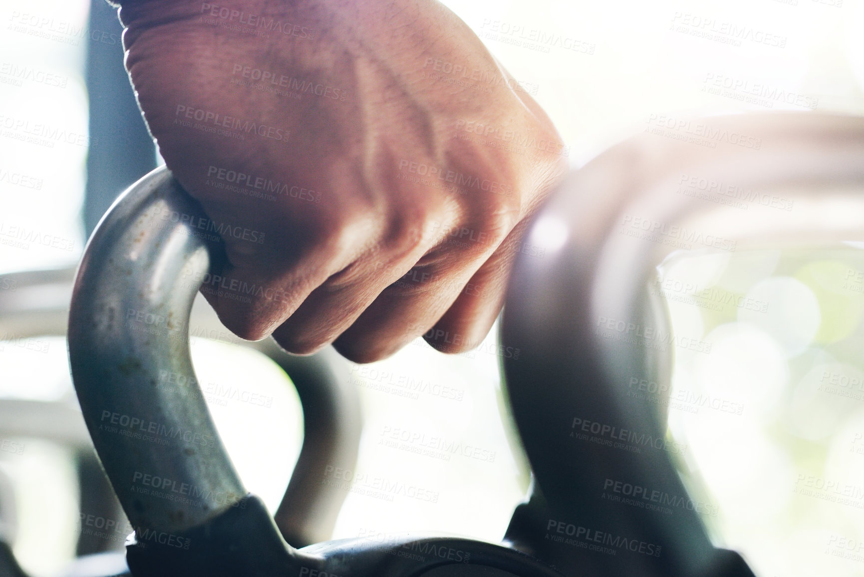 Buy stock photo Cropped shot of an unrecognizable sportsman lifting kettle bells in a gym
