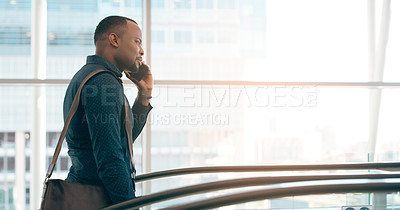 Buy stock photo Cropped shot of a handsome young businessman taking a phonecall while going up an escalator in a modern workplace