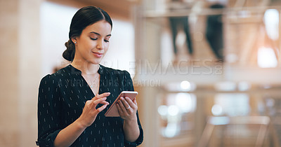 Buy stock photo Cropped shot of an attractive young businesswoman using a smartphone while standing in a modern workplace