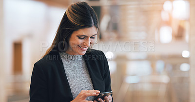 Buy stock photo Cropped shot of a an attractive young businesswoman smiling while using smartphone in a modern workplace