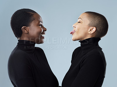 Buy stock photo Women, profile and tongue out for fashion in studio or emoji for style inspiration or joke. Lesbian couple, lgbtq community and pride for partner, outfit and winter trend or comedy by gray background