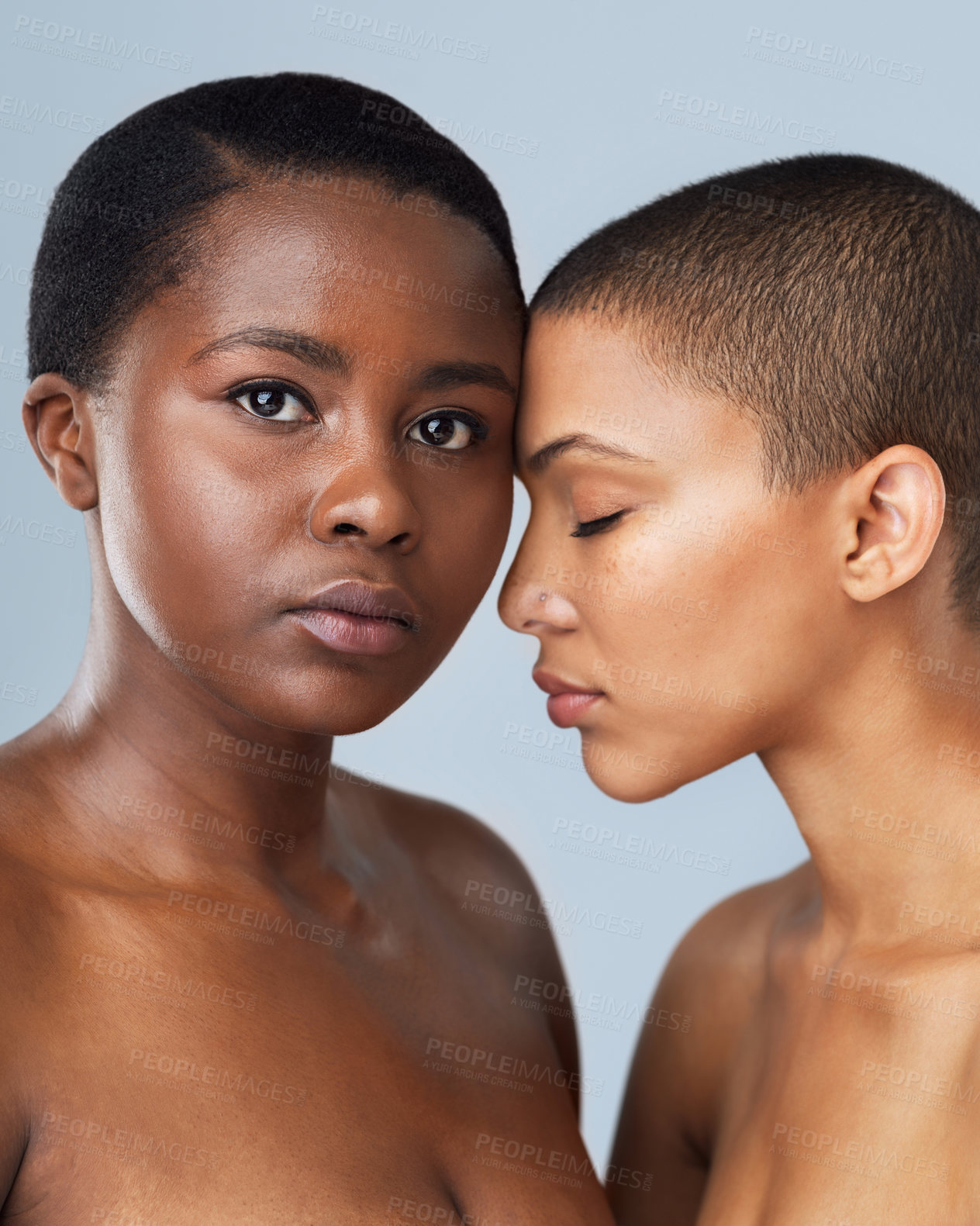 Buy stock photo Portrait of two beautiful young women standing close  to each other against a grey background