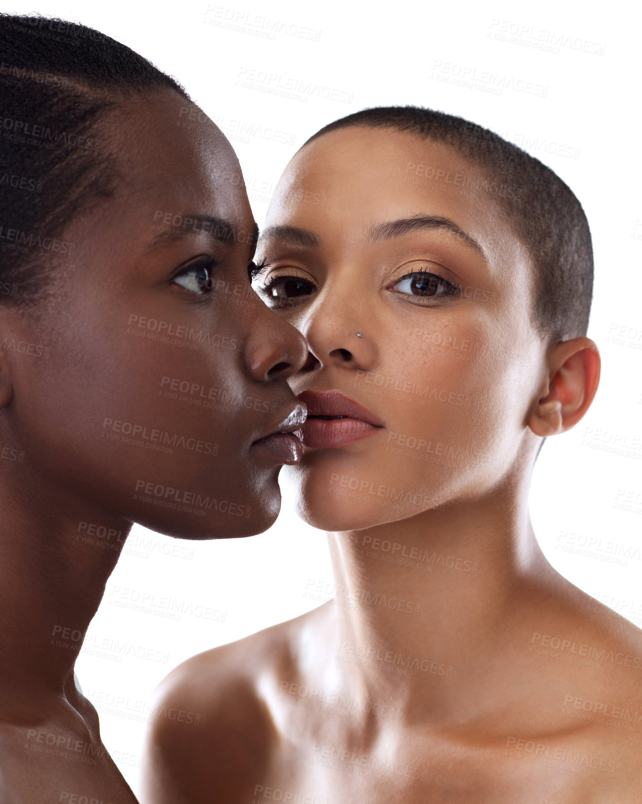 Buy stock photo Portrait shot of two beautiful young women holding each other while standing against a grey background