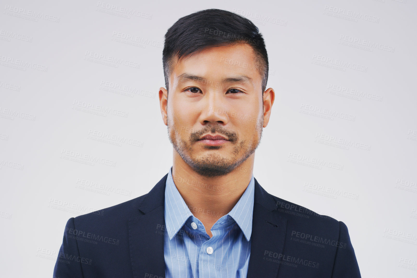 Buy stock photo Studio portrait of a handsome young businessman posing expressionless against a grey background