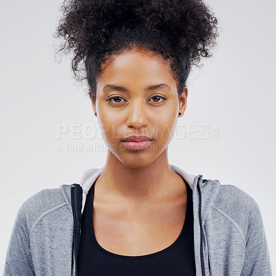Buy stock photo Studio portrait of an attractive young woman posing expressionless against a grey background