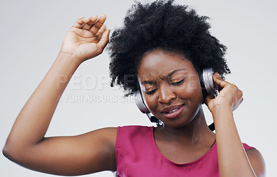 Buy stock photo Dancing, music or happy black woman in headphones in studio for singing on grey background. Model, face or African girl listening to radio playlist, sound or podcast audio with afro or subscription