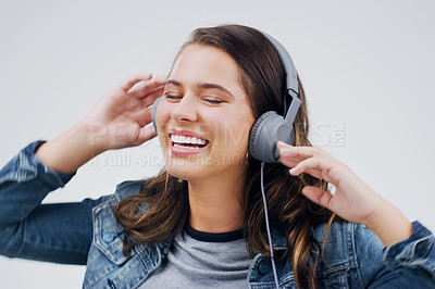 Buy stock photo Headphones, dance or happy woman streaming music in studio for singing on grey background to relax. Model, podcast or girl listening to radio playlist, sound or song audio on an online subscription