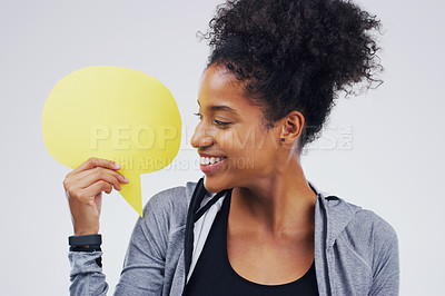 Buy stock photo Shot of an attractive young woman holding speech bubble against a grey background