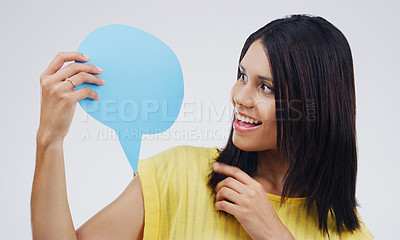 Buy stock photo Shot of an attractive young woman looking surprised while holding a speech bubble against a grey background