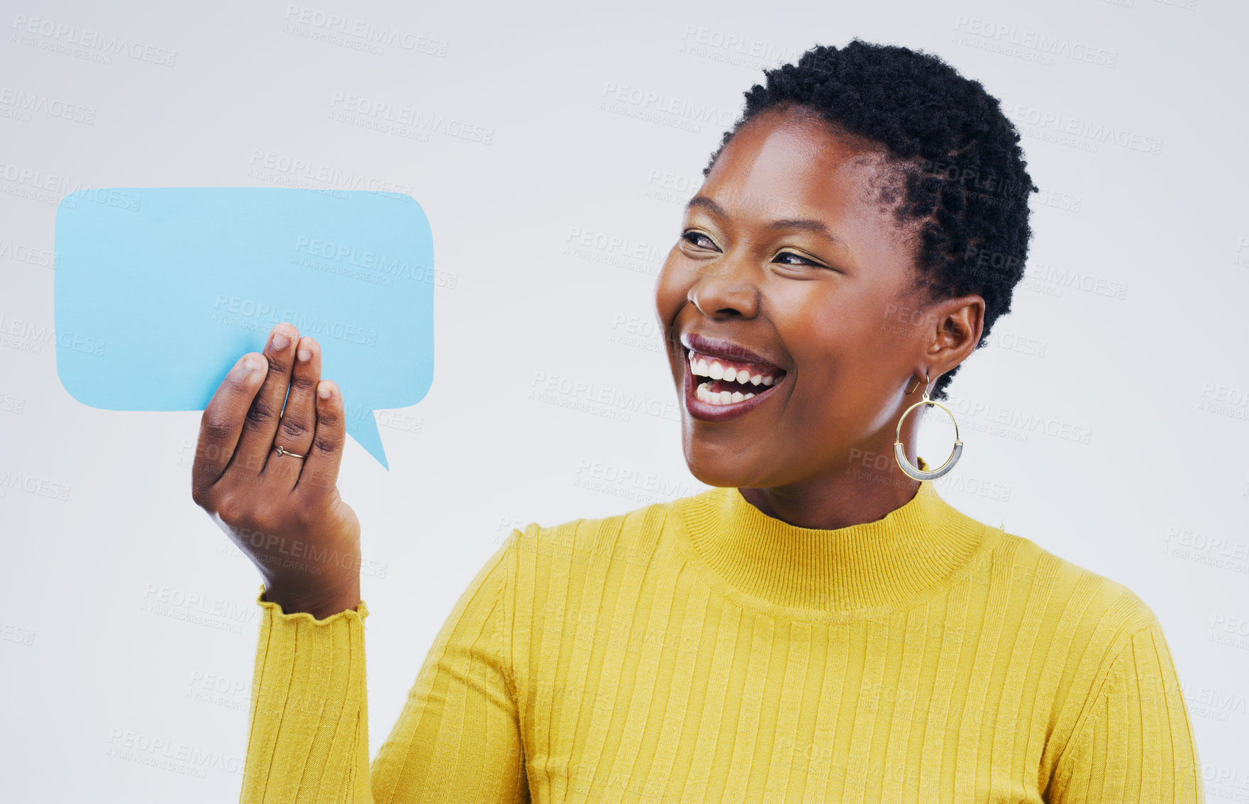 Buy stock photo Shot an attractive young woman looking surprised while holding a speech bubble against a grey background