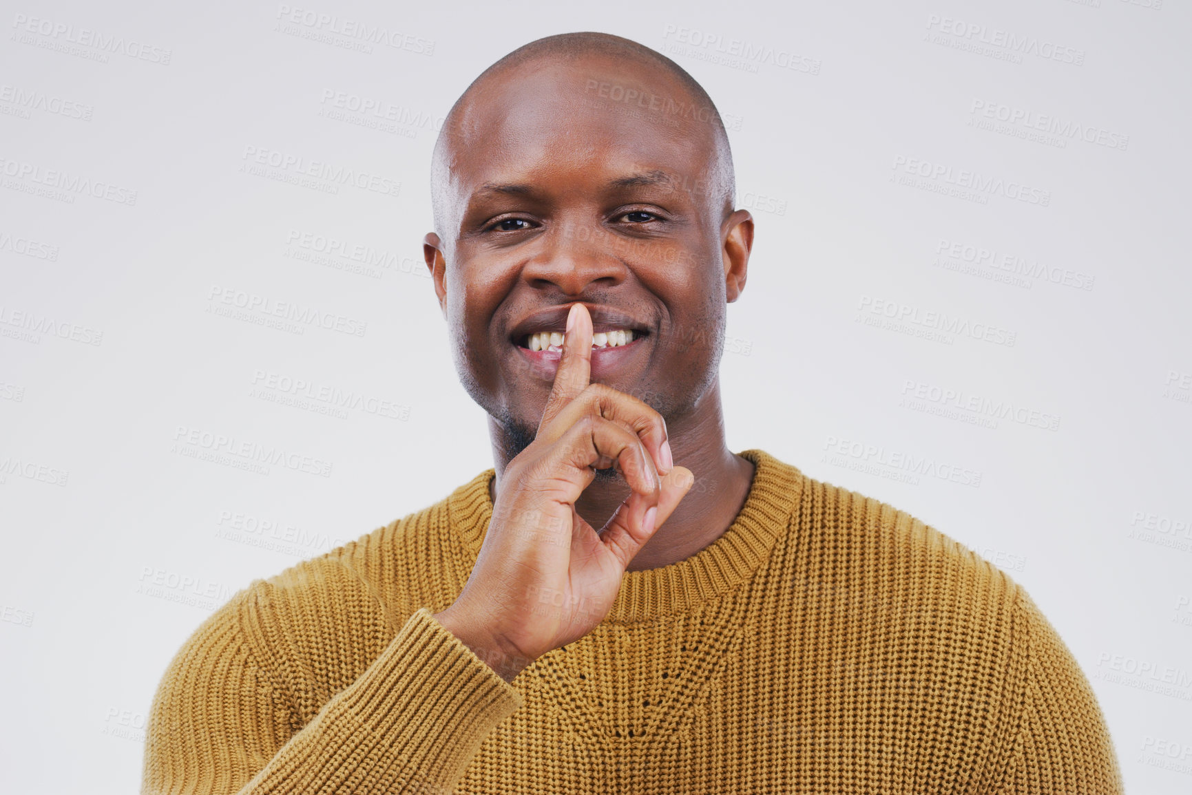 Buy stock photo Portrait, smile and shush with private black man in studio isolated on gray background for mystery. Face, finger on lips and silent with emoji hand gesture of happy bald person to whisper gossip