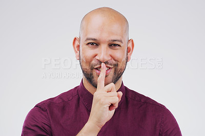 Buy stock photo Portrait, smile and shush with secret man in studio isolated on gray background for mystery. Face, finger on lips and happy with emoji hand gesture of confident bald person for silent whisper