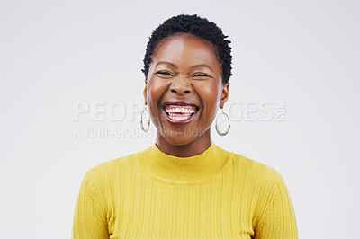 Buy stock photo Studio portrait of an attractive young woman laughing while standing against a grey background