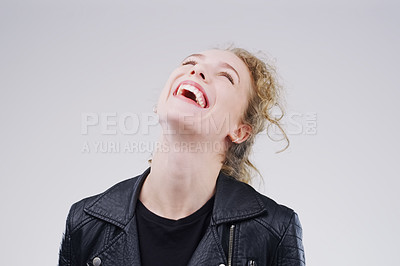 Buy stock photo Studio shot of an attractive young woman laughing while standing against a grey background