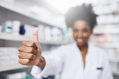 Buy stock photo Shot of a confident young pharmacist showing thumbs up in a chemist