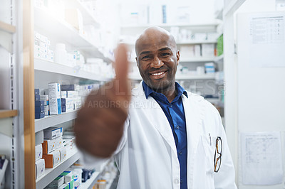 Buy stock photo Shot of a confident pharmacist showing thumbs up in a chemist