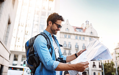 Buy stock photo Cropped shot of a handsome young man looking at a map while touring a foreign city