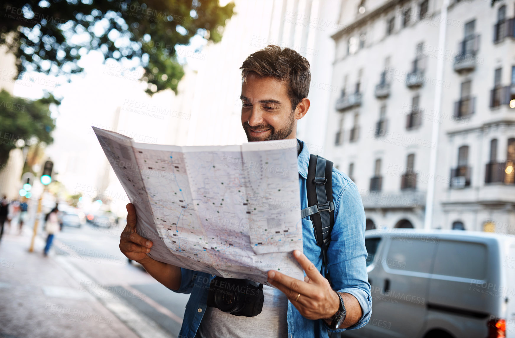 Buy stock photo Cropped shot of a handsome young man looking at a map while touring a foreign city