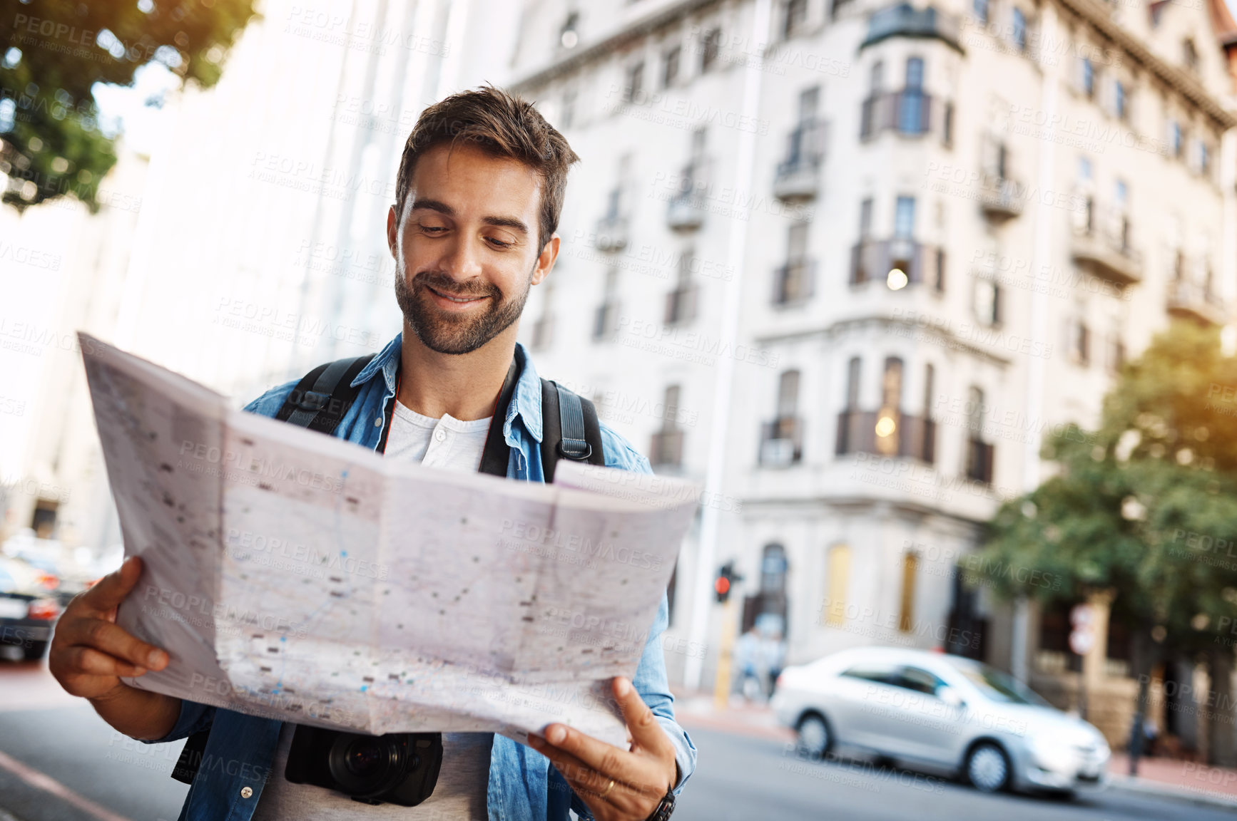 Buy stock photo Cropped shot of a handsome young man looking at a map while touring a foreign city