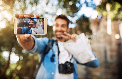 Buy stock photo Man, phone screen and travel selfie outdoor in a city with holiday memory, smile and peace sign. Male person outdoor for adventure, journey or vacation photo and freedom with hand for emoji or icon