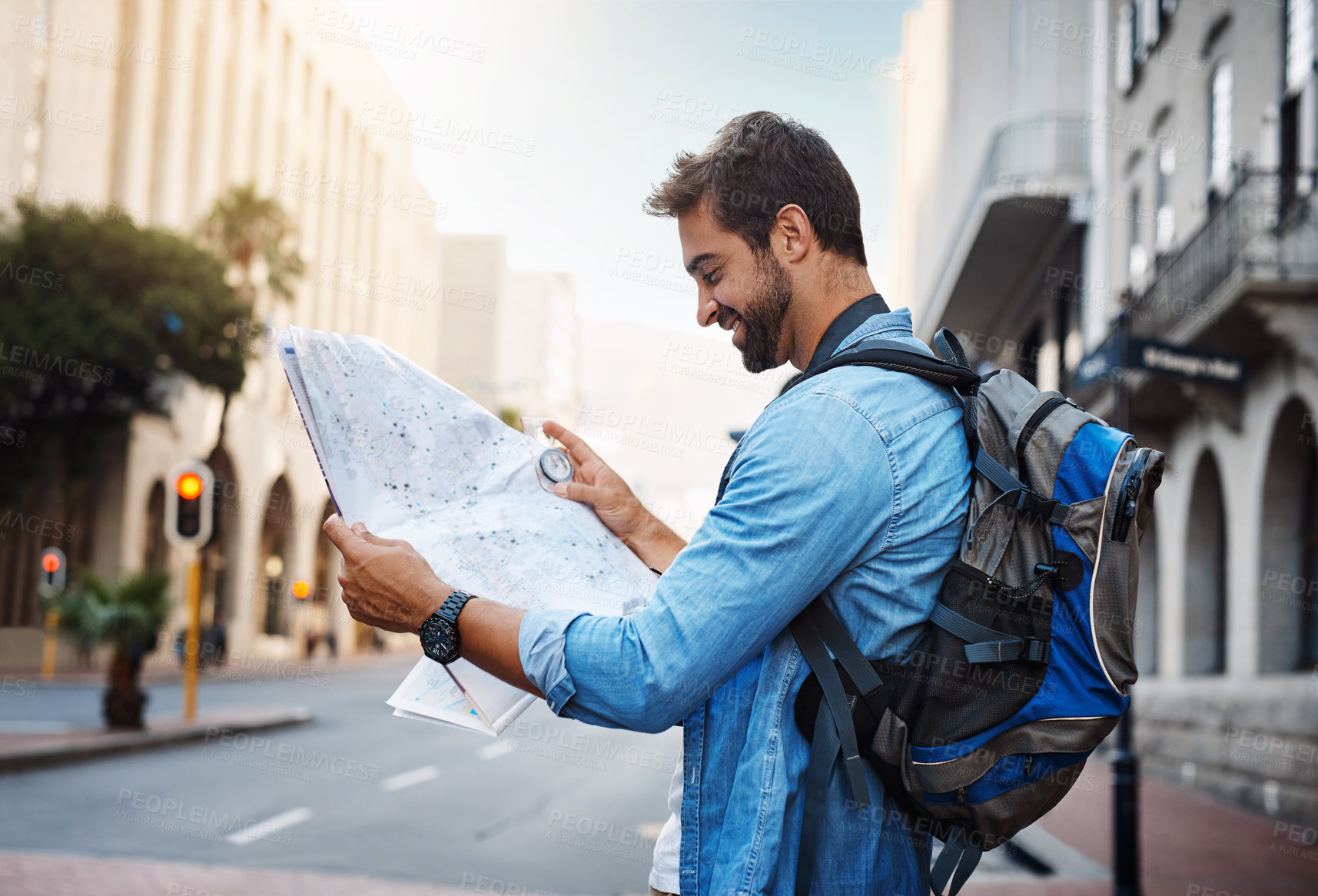 Buy stock photo Cropped shot of a handsome young man looking at a map while touring a foreign city