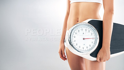 Buy stock photo Studio shot of an urecognizable slim woman holding a weight scale against a grey background
