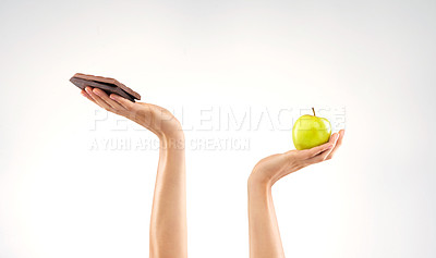 Buy stock photo Studio shot of an unrecognizable woman deciding between healthy and unhealthy foods against a grey background