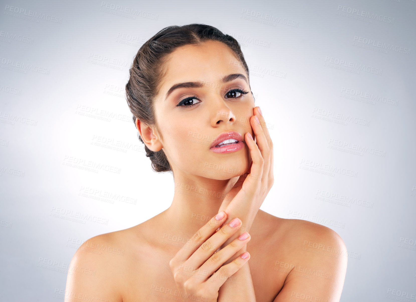 Buy stock photo Studio portrait of a beautiful young woman with gorgeous skin holding her face against a grey background